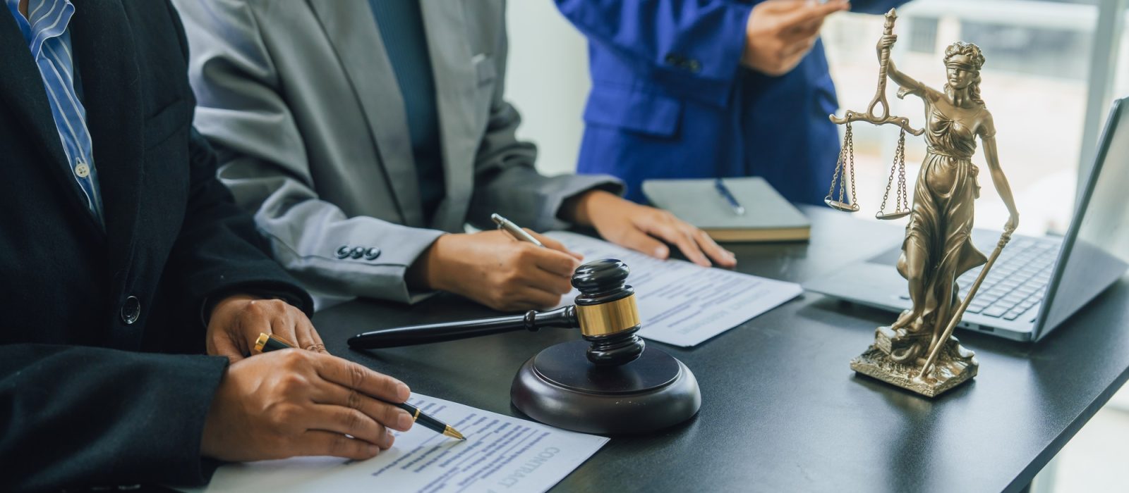 Business lawyer team working with law firms contracts in working room.