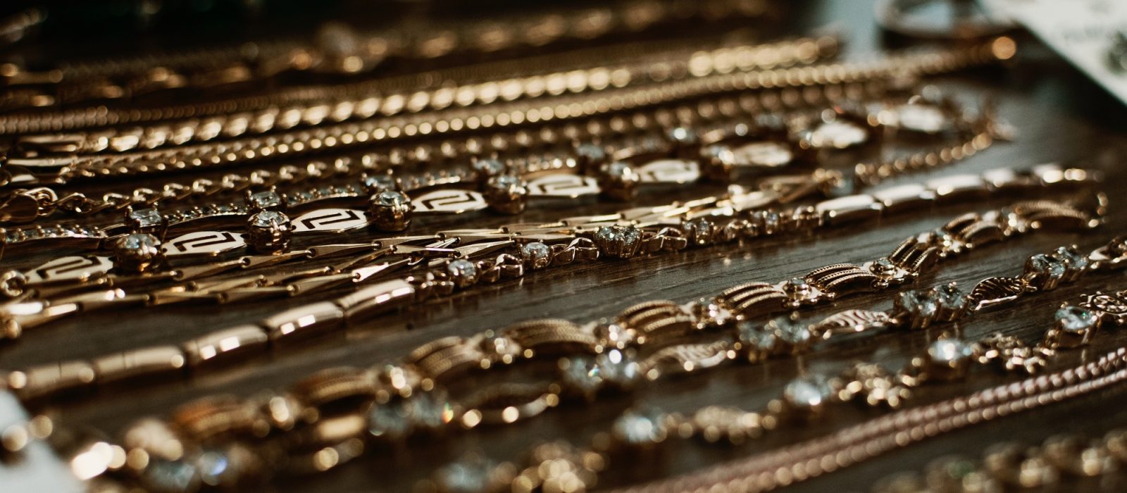 luxury gold jewelry chains, bracelets background, selective focus. Stylish beautiful bijouterie